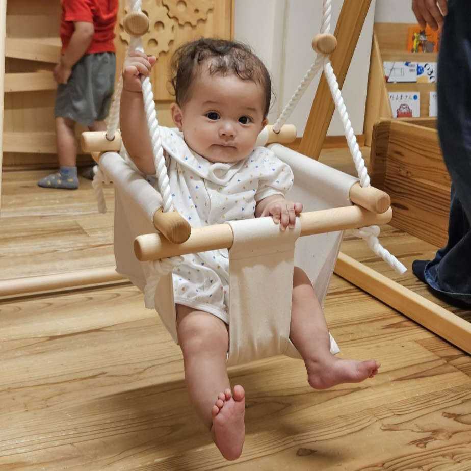 プレイルームのブランコで遊ぶ赤ちゃん