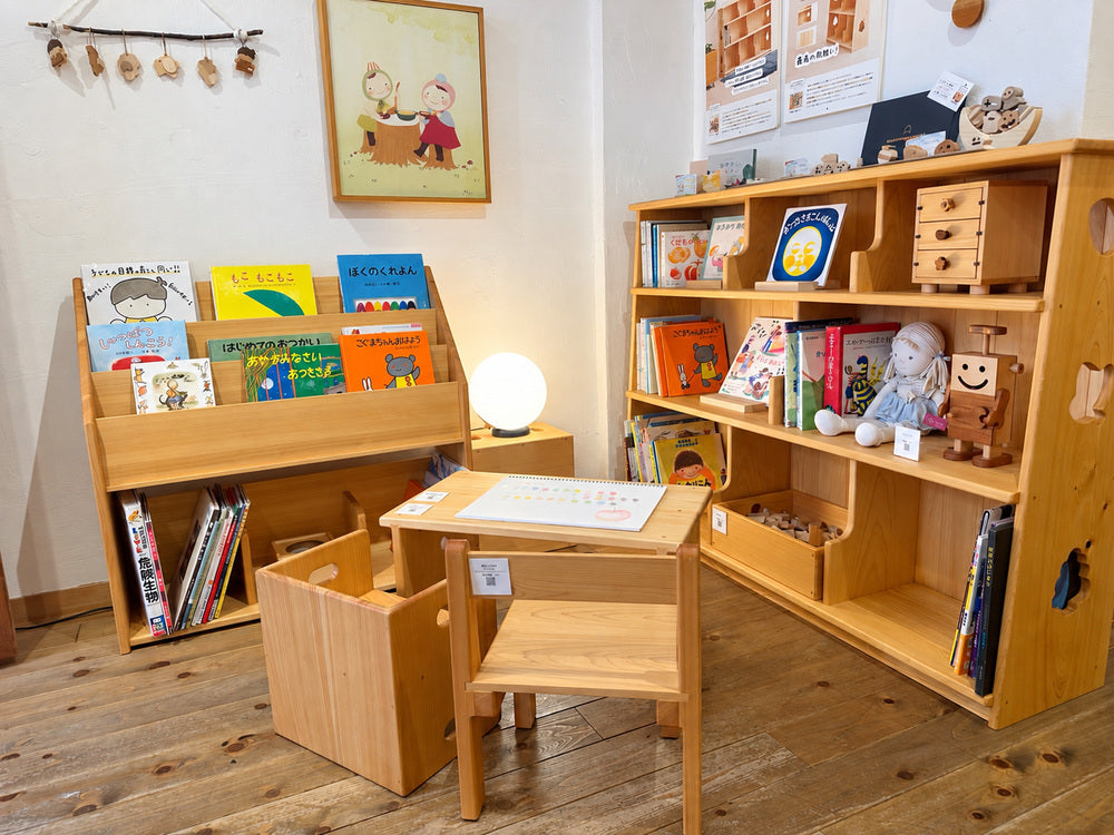 絵本棚と木製の机、子ども用の椅子を組み合わせた神戸店の展示。